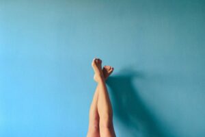 Legs crossed on blue wall