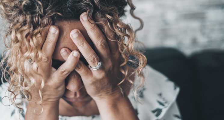 Bad emotions and problems for a worried and desperate woman holding head with hands. People and depression disease. Female wife after divorce or home violence crime. Mind unhealthy condition lady